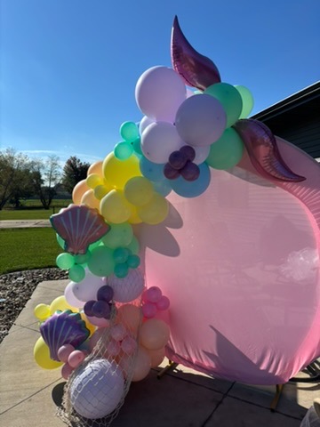 Mermaid themed balloon garland on pink circle backdrop