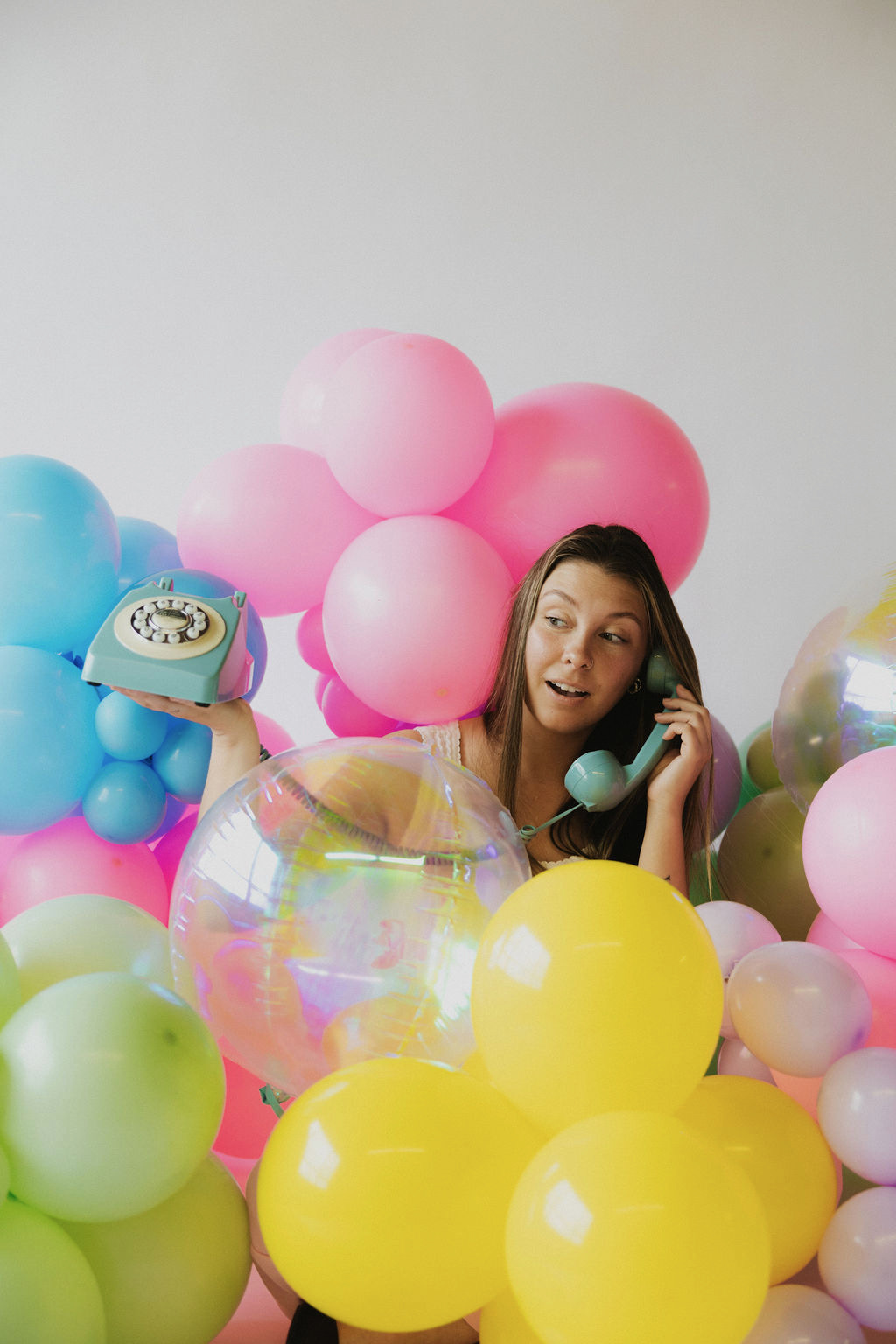 Jenni having fun with a retro phone among the balloons