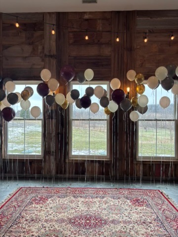Floating balloon clusters in black cream and gold at barn wedding